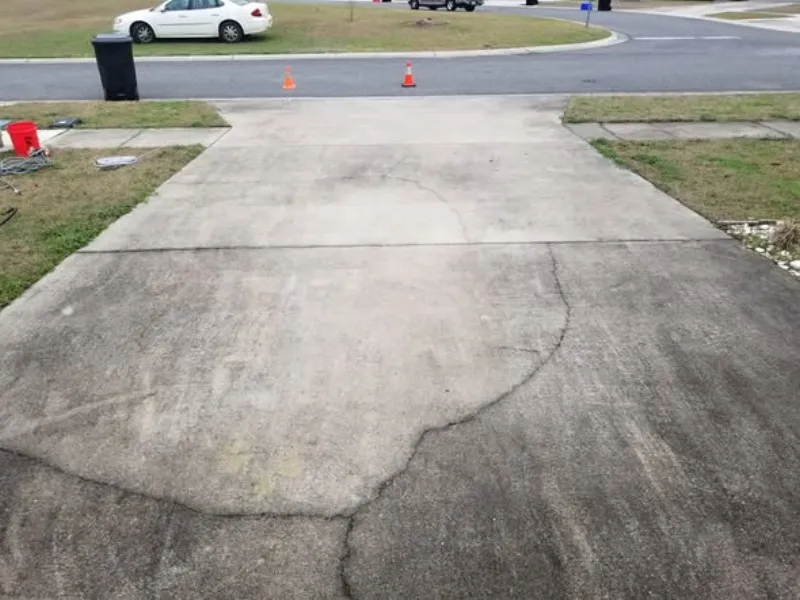 Stained concrete driveway with dark traffic grime